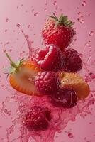 Fresh berries create a splash in vibrant pink liquid, capturing a lively and fruity moment photo