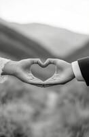 Couples hands forming a heart shape against a serene background during a romantic moment photo