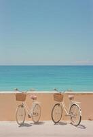 Two vintage bicycles with wicker baskets overlooking a serene ocean view by the beachside walkway photo