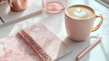A cozy workspace with a cup of latte, stylish sunglasses, and a notepad on a marble background photo