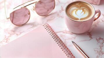 A cozy workspace with a cup of latte, stylish sunglasses, and a notepad on a marble background photo