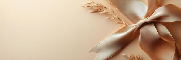 Elegant golden ribbon tied on a soft beige background for gift wrapping or decoration photo