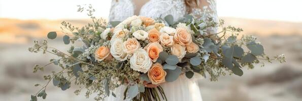 Bridal bouquet of roses and greenery at sunset in an outdoor desert setting photo