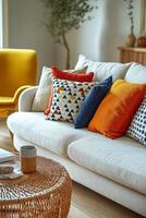 Bright and cozy living room with colorful pillows on a light sofa and a wicker coffee table photo