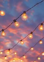 Colorful twilight sky with glowing light bulbs hanging above an outdoor setting photo