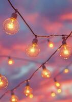 Colorful twilight sky with glowing light bulbs hanging above an outdoor setting photo