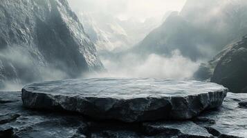Misty mountain range with a large rock platform amidst dramatic clouds at dawn photo