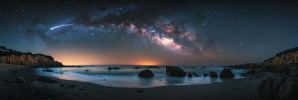 Captivating view of the Milky Way over a serene beach at night with rocks and gentle waves photo
