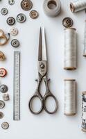 Crafting supplies and tools neatly arranged on a white background with various threads and buttons photo