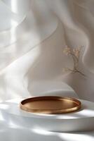 A golden circular object rests on soft fabric with flowing sheer drapes in a serene setting photo