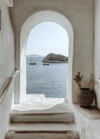 A beautiful coastal view through an archway on a sunny day with boats in the distance photo