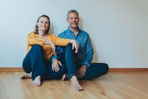 A happy couple is having fun at home while sitting on the floor. photo