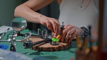 Creating intricate models in a workspace with tools and materials on a wooden base in the evening video