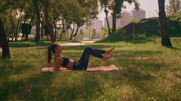 Outdoor fitness routine featuring core exercises on a mat in a sunny park video