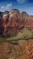 Drone flying into the crack between beautiful canyons. Clouds over the mountains throwing shadows on rocks. Vertical video