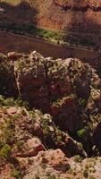 Looking at the tops of amazing canyons with little greenery. High sharp rocks towering over the desert in Utah, USA. Vertical video