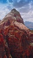 Pointed tops of mountains in the light of bright sunshine. Canyons of Zion National Park in Utah, USA from aerial perspective. Vertical video