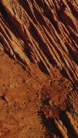 Stunning rocks of American canyons on sunny daytime. Highway road passing through the dry desert in Utah State from top view. Vertical video