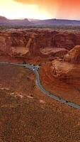 Grey road going across the plain near beautiful rocks of Zion Canyon. Breath-taking view of mountains at the backdrop of pink skies. Vertical video