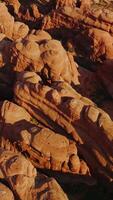 Strangely-shaped rocks in Arches National park in Utah, USA. Circling over a group of weird rocks in Canyons. Top view. Vertical video