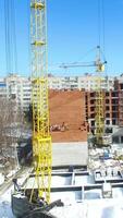 Hoisting cranes and building activity. Aerial view of crane and building construction site in winter season video