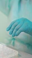 Preparation for blood test. Doctor hand taking a blood sample tube from a rack with machines of analysis in the lab background video