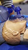 Training course on a manikin. Practitioners giving breath exercises on a dummy at resuscitation. Compression during heart attack on a mannequin. Vertical video