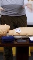 Trainer teaching medical skills on a mannequin. Instructor showing practical methods for giving first aid on a dummy. Healthcare and medical concept. Vertical video