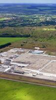 Modern plant in the countryside. Industry among beautiful green nature. Factory in environment in summer. Aerial view. Vertical video