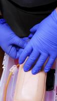 Practical procedure with an injection. Student practices to injection into dummy's hand in the training center. Top view. Close-up. Vertical video