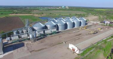 Aerial View Of Big Grain Elevators. Aerial view of grain elevators surrounded by green fields video