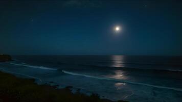 Moonlit ocean waves gently roll onto a sandy beach at night, creating a serene and peaceful scene under the starry sky. video