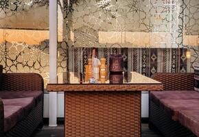 Relaxing living room scene. a wicker coffee table with a glass top and a plush couch positioned beneath a window photo