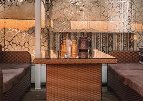 Relaxing living room scene. a wicker coffee table with a glass top and a plush couch positioned beneath a window photo