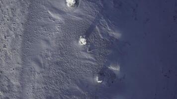 Aerial top view over snow covered stone blocks and white valley. Clip. Manpupuner in winter, endless white desert. photo