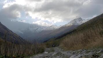 Big high mountains. Creative. Huge hills covered with snow and overgrown with green fir trees and pine trees around photo