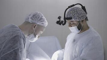 Surgeons operate on patient under anesthesia. Action. Operation process with professional surgeons. Surgeons during surgery with professional look photo