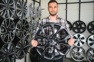 man chooses new alloy wheels in auto shop photo