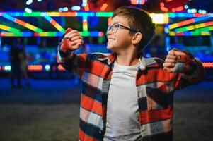 A handsome and happy boy is having fun in the amusement park photo