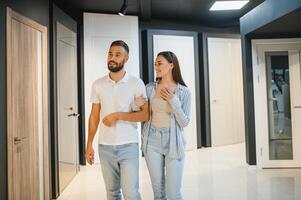 Portrait of smiling young man and woman shopping in the hardware store choosing different door options photo