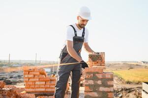 Construction worker in uniform and safety equipment have job on building photo