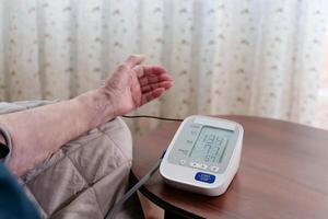 An impersonal woman measures vital signs with a tonometer, the numerical display at the center of the conceptual health care image photo