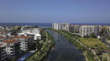 The view from the drone. Clip. View of the blue clear ocean near the resort area with a swimming pool and houses . photo