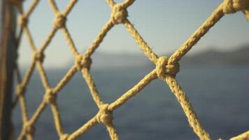 Rope net close up while yacht is moving, sea view, blurred frame video