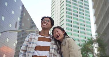 Beautiful asian couple portrait looking at camera smiling and laughing during the sunset in a modern city. video
