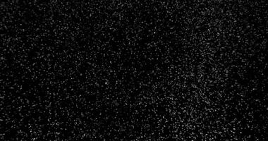 Snow falling on black background in slow motion. Winter weather atmosphere overlay filmed with RED camera video