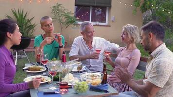 Group of mature happy friends with wine together in dinner party. Smiles, cheerfulness concept. video