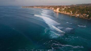 Drone view of coastline with cliffs and ocean with surfing waves near Padang Padang beach video