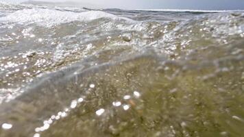 waves on the shore of a beach in summer, footage recorded at sea surface level, summer beach background concept video