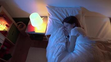 Top view of a beautiful girl sleeping cozily on a bed in her night room with Blue Colors from the moon. video